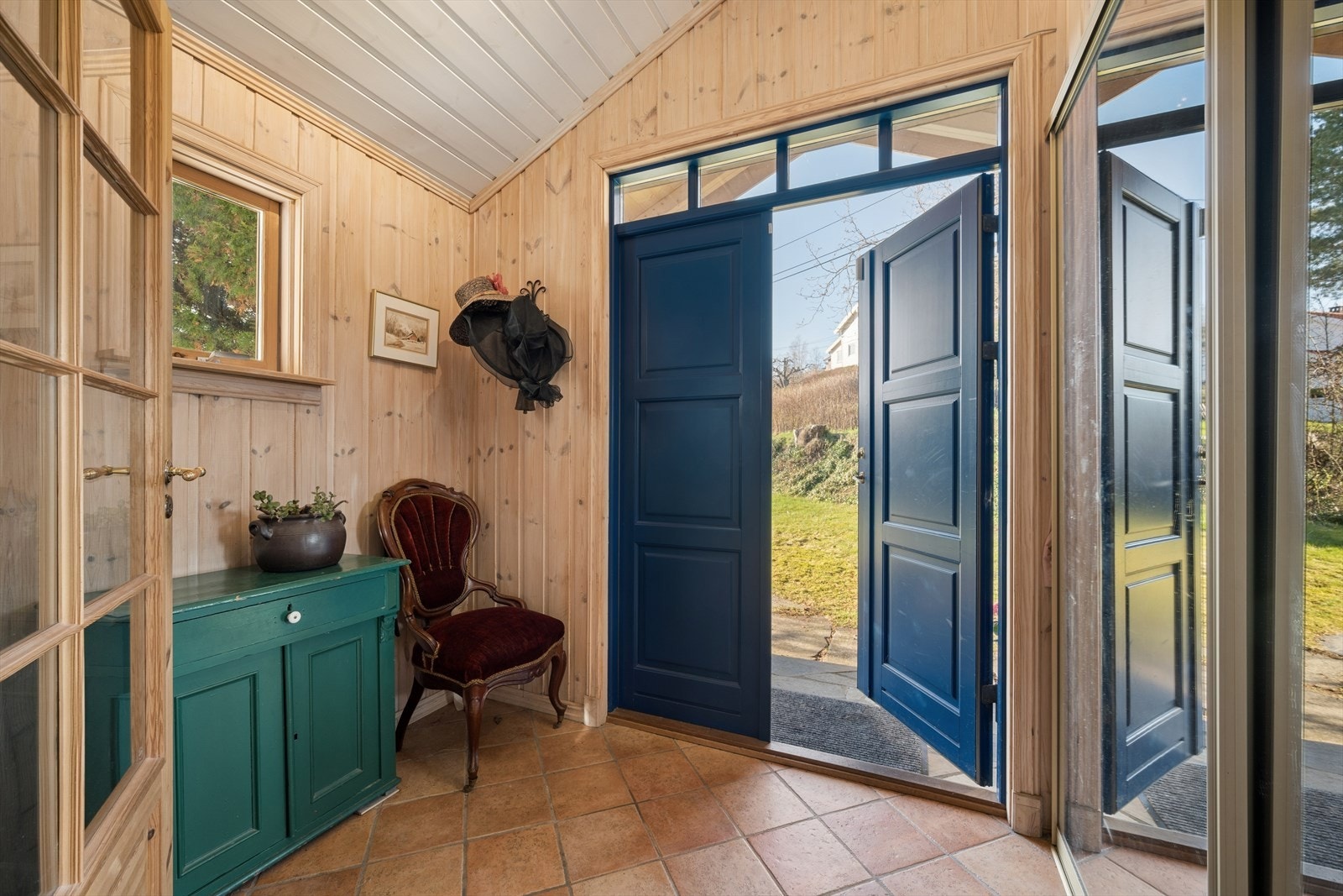 Flislagt entré med god plass til å sette fra seg sko og yttertøy. Rommet har høy takhøyde. Galleribilde
