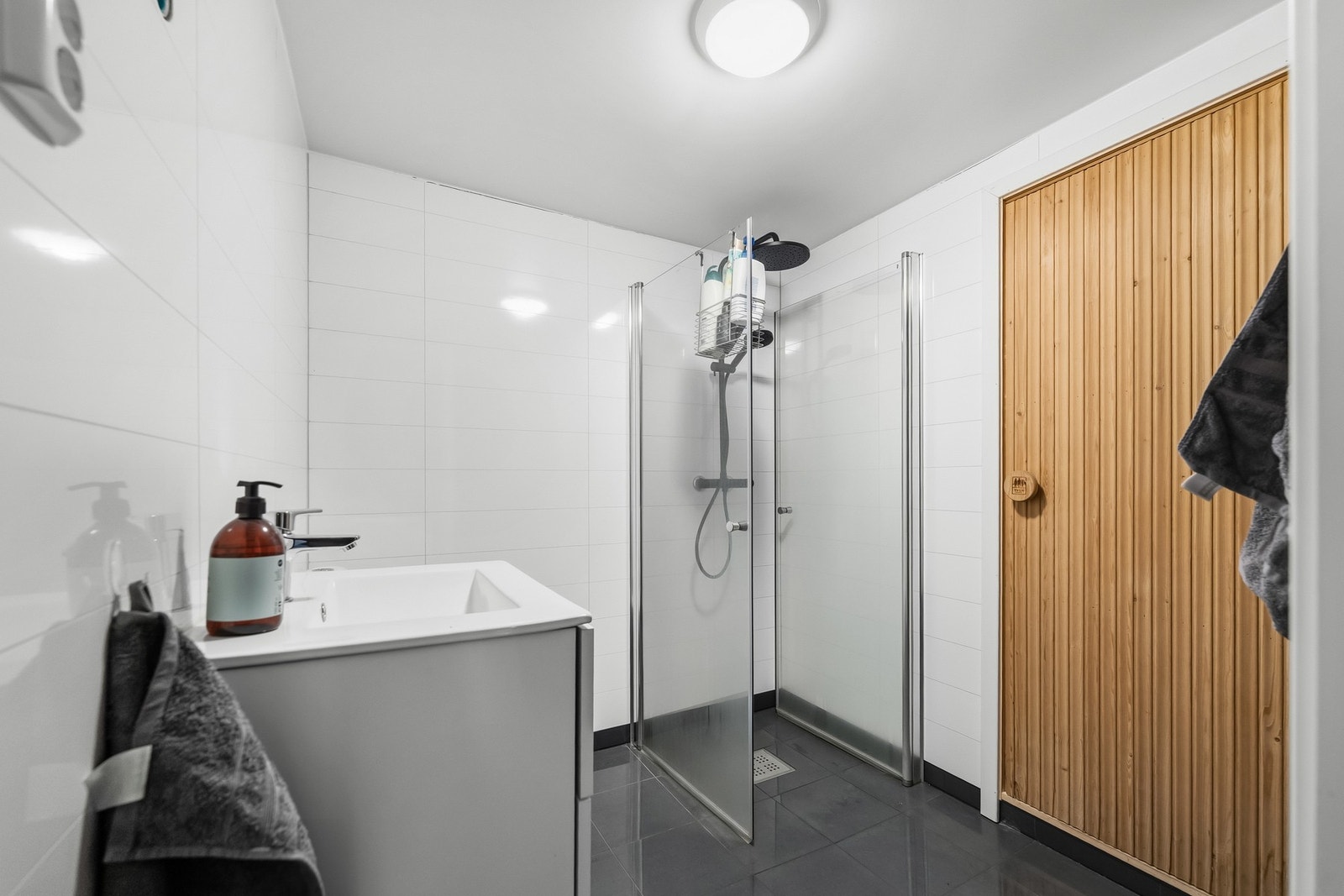 Badet er etablert i 2024 og fremstår med en moderne og praktisk utforming. Gulvet er flislagt med varmekabler, mens veggene er utført med baderomsplater og himlingen har malte, glatte flater. Rommet er innredet med servant med underskap, gulvmontert toale Galleribilde