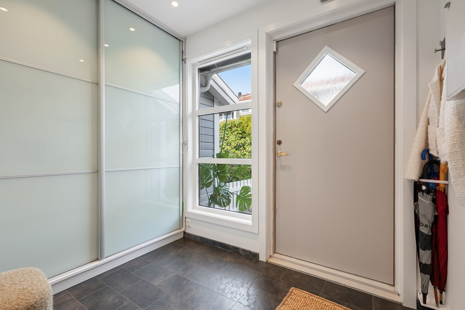 Entreen har flislaminat på gulvet, lysmalte vegger og hvit himling med downlights. Rommet har også en praktisk skyvedørsgarderobe, så her er det enkelt å rydde bort yttertøy, sko med mer. Galleribilde