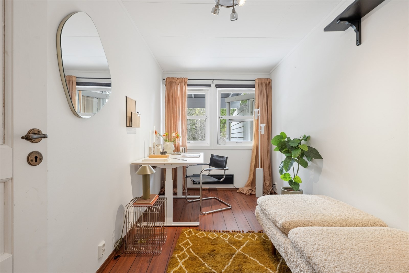 Rommet har vinduer som slipper inn lys, og det er plass til både arbeidsstasjon og sitteområde. Galleribilde