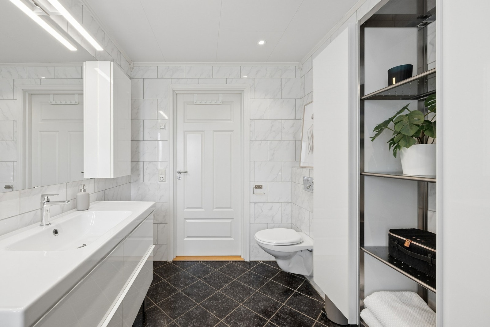 Badet er innredet med nedfelt servant, toalett og dusjhjørne. Galleribilde