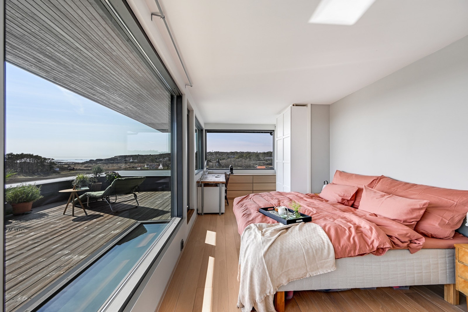 Hovedsuiten i andre etasje har parkettgulv og store vinduer mot havet. Herfra er det direkte utgang til den private, sørvendte takterrassen på 34 m². Galleribilde