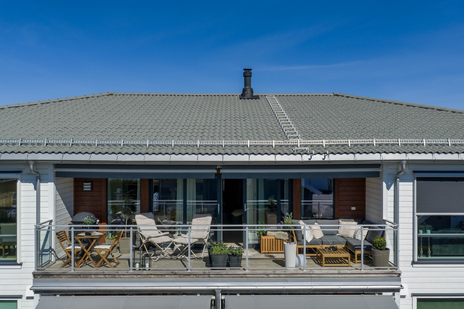 Stuen har en stor skyvedør som åpner opp for en elegant og sømløs overgang mellom inne- og utearealene på varme sommerdager. Galleribilde