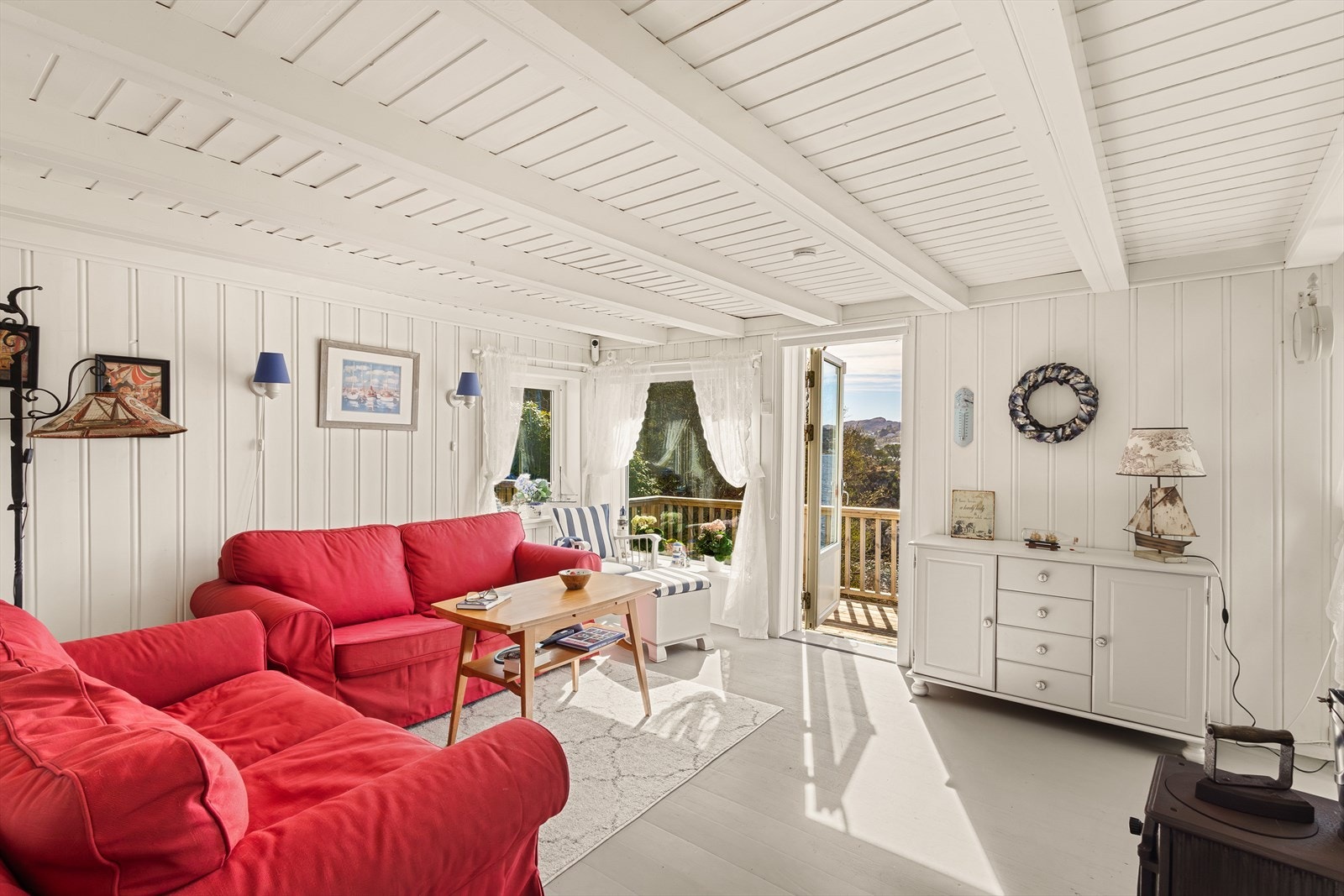 Maritim stue med vedovn og utgang til herlig terrasse på vestsiden av hytten. Galleribilde