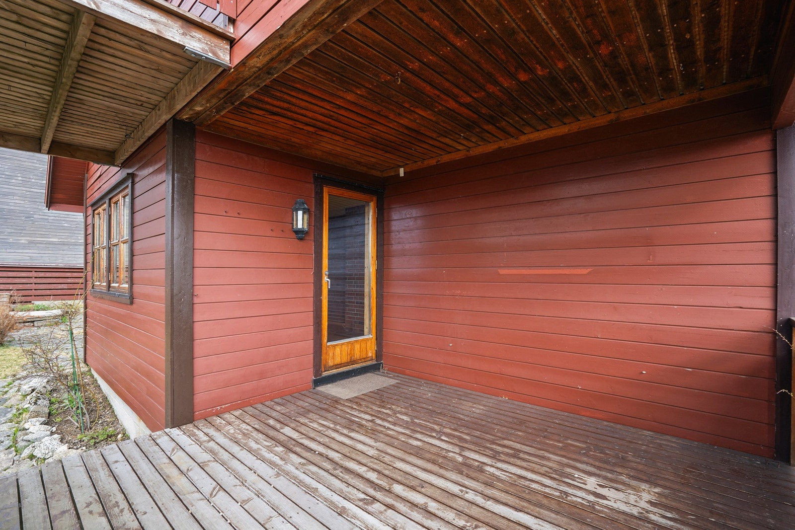 Terrasse med utgang fra boligens stue. Uteplassen er delvis overbygget, noe som gjør den mer anvendelig uansett vær. Galleribilde