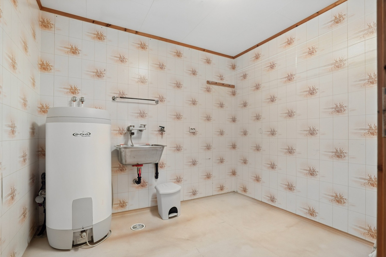 Praktisk vaskerom i kjeller med opplegg for vaskemaskin. Rommet har utslagsvask. Galleribilde