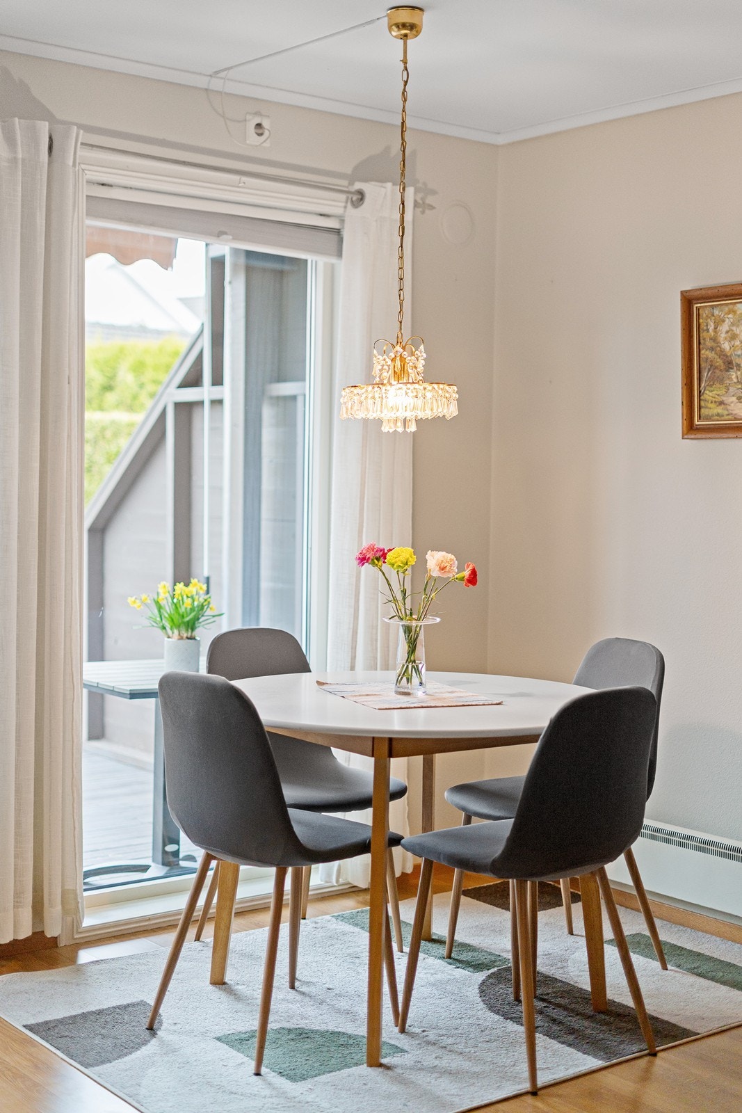 Spisebordet er plassert ved vinduet og i nærhet til kjøkkenavdelingen, noe som gir en praktisk og naturlig flyt mellom matlaging og måltider. Galleribilde