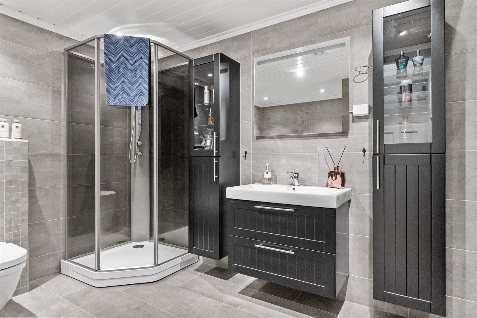 Badet i hovedetasjen er utstyrt med badekar, dusj, vegghengt toalett og servant med skuffinnredning. Galleribilde