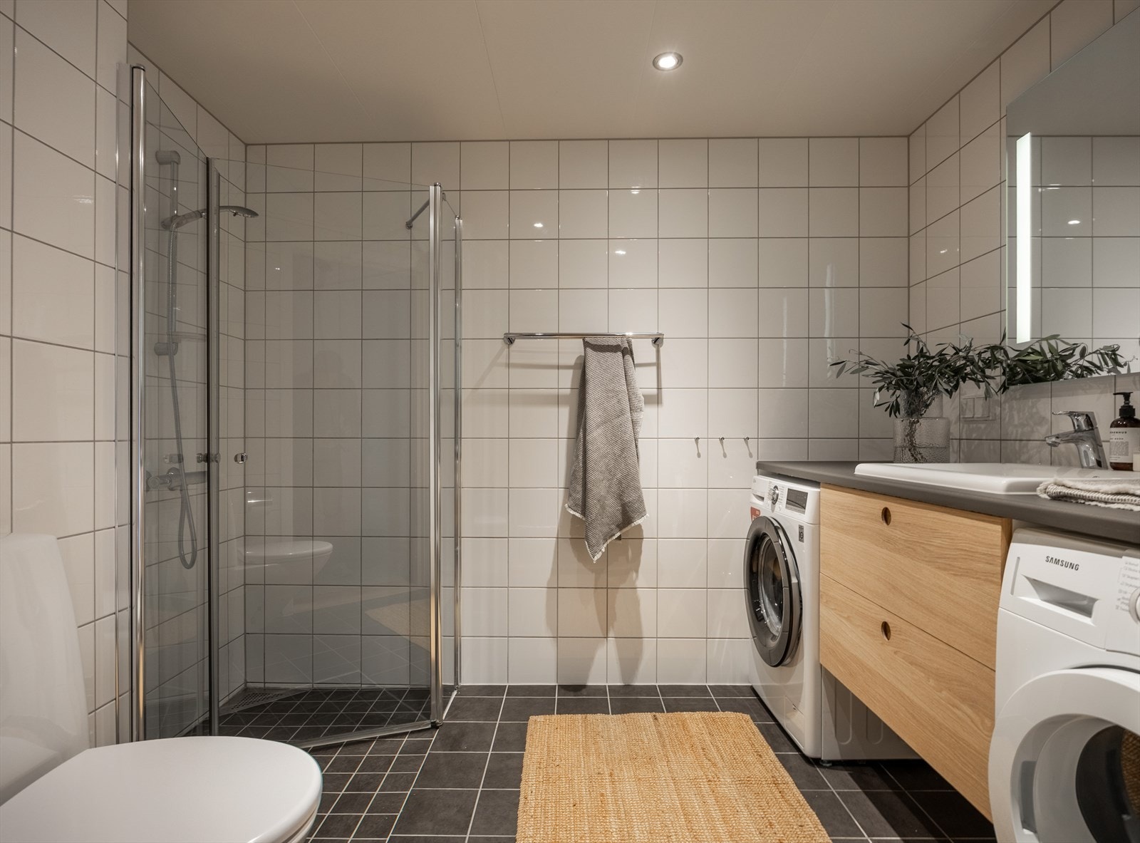Lyst flislagt baderom med varmekabler i gulv og downlights i himling. Galleribilde