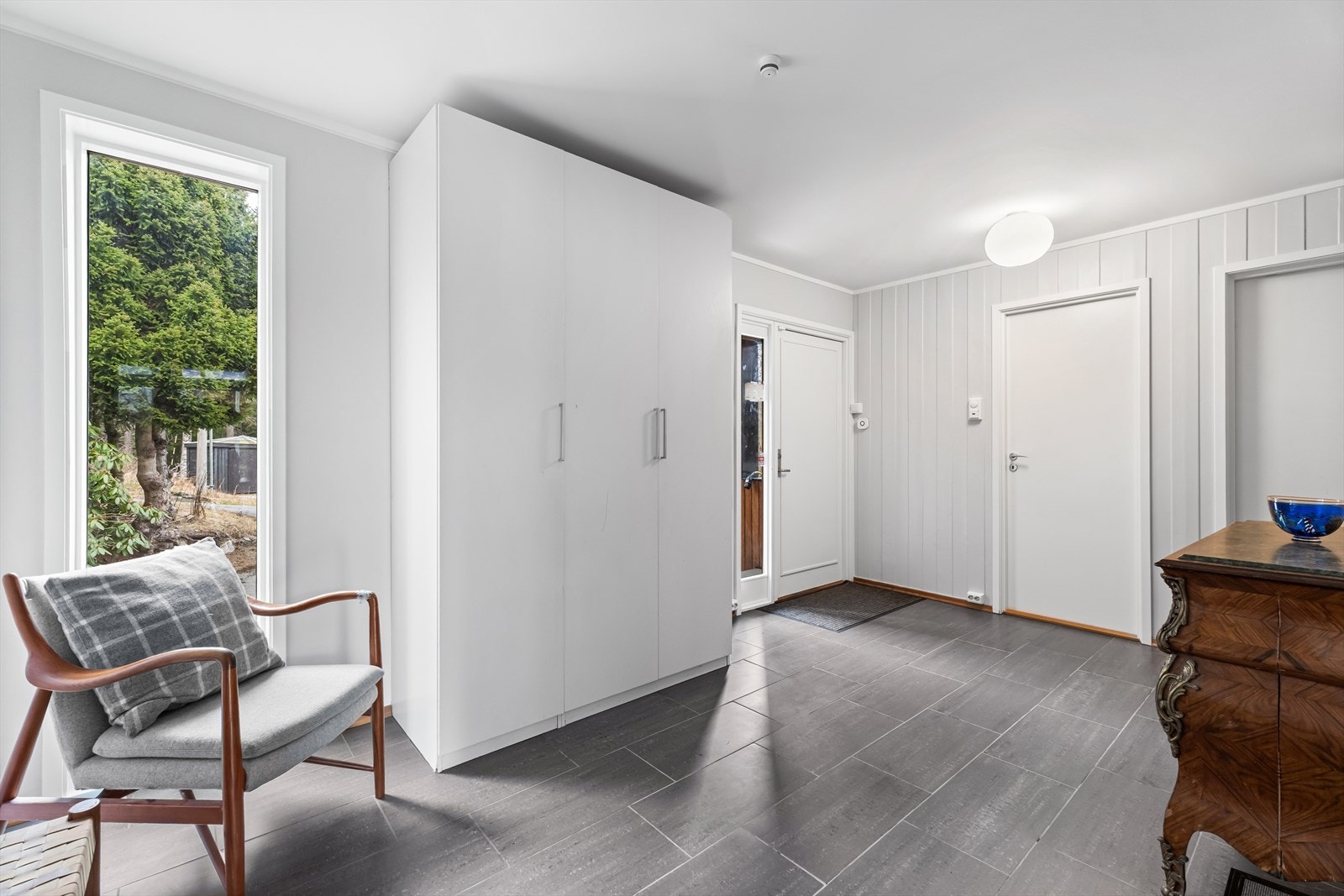 Stor flislagt entré/hall med garderobeskap. Adkomst til soverom, bad, spisestue og trapp. Galleribilde