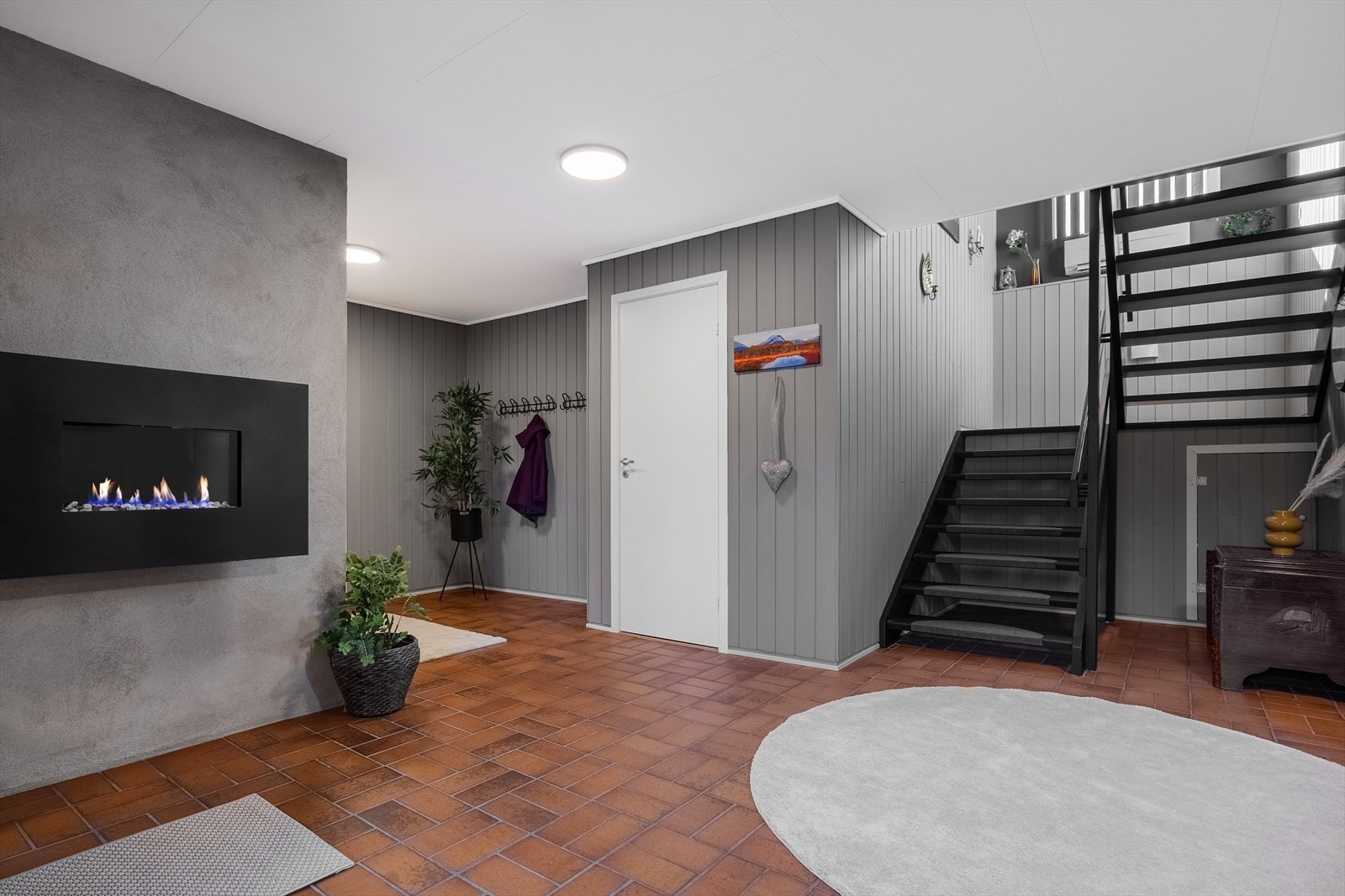 Romslig hall i sokkeletasjen som gir et godt førsteinntrykk. Herfra er det tilgang til kjellerstue, bad og trapp til hovedetasjen. Galleribilde
