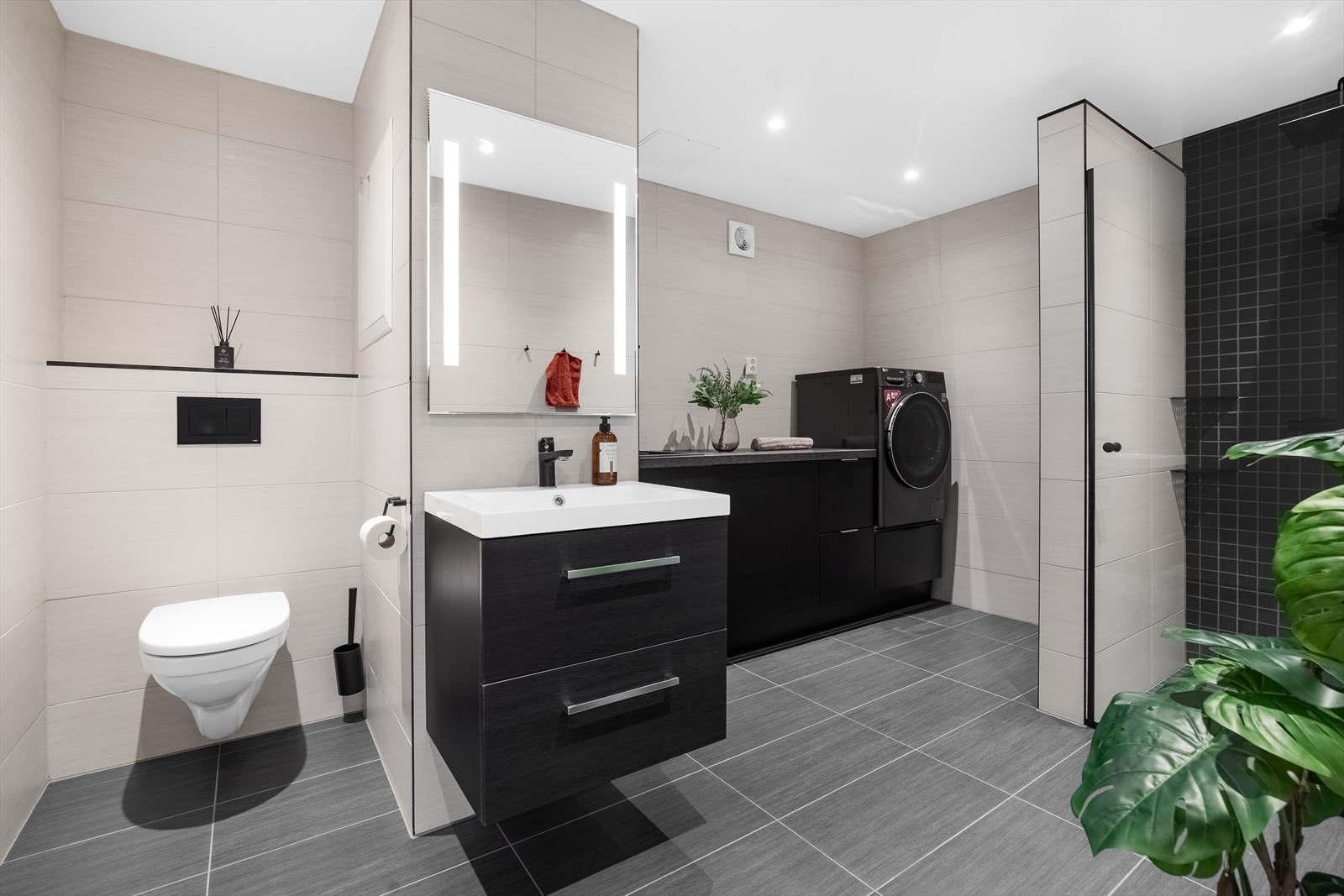Badet i sokkeletasjen er også fra 2021, med flislagte overflater, dusjsone og praktisk opplegg for vaskemaskin. Galleribilde