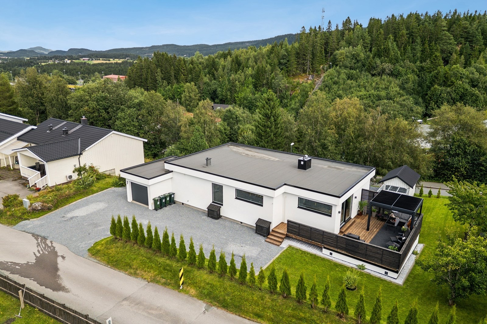 Eiendommen ligger fint til i terrenget med marka i bakgrunnen. Galleribilde