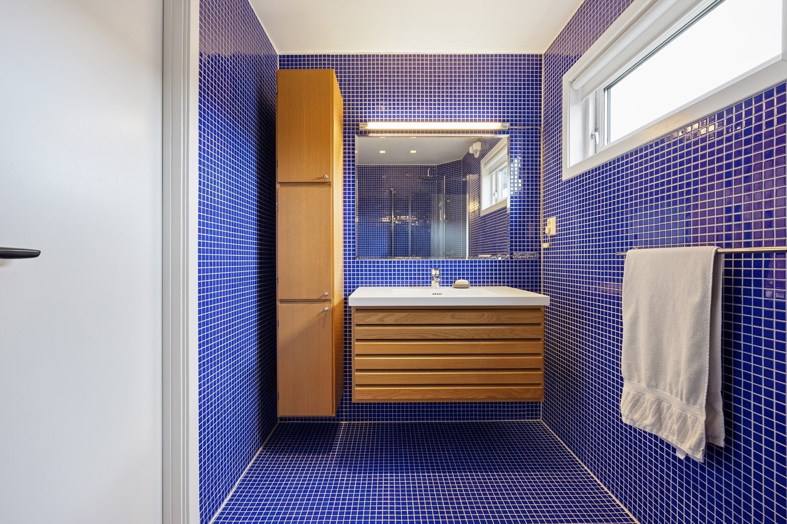 Gjennomgående blå mosaikkfliser gir badet et særpreg og et eksklusivt uttrykk. Galleribilde