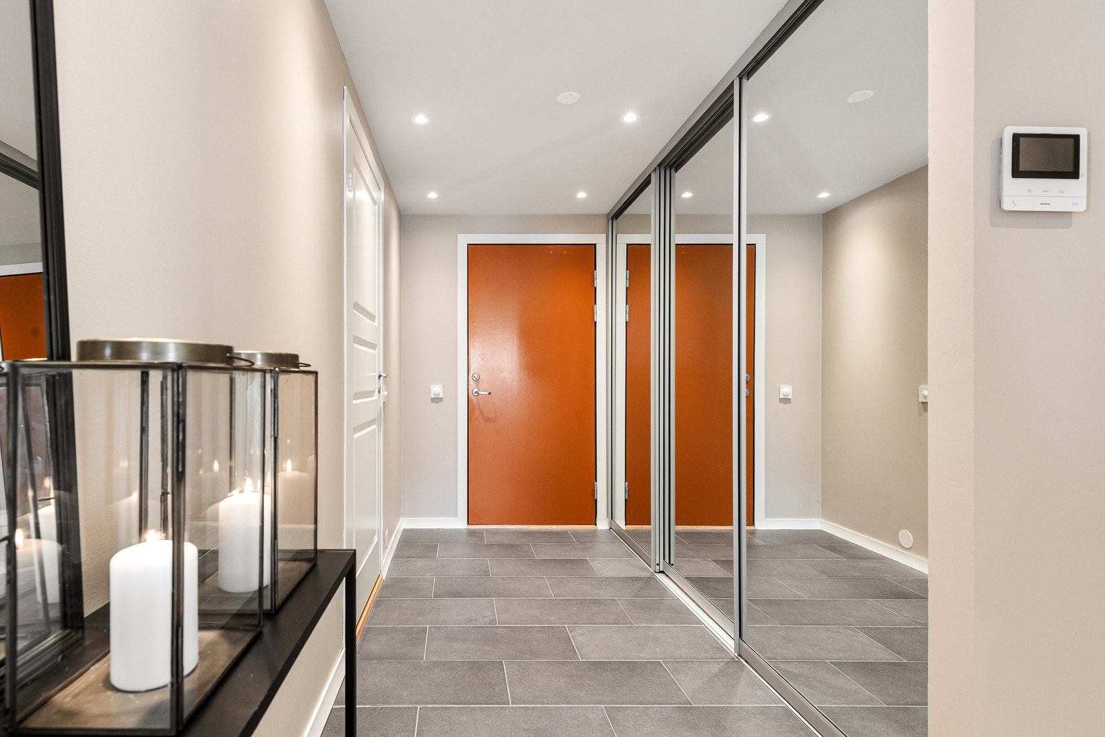 Entréen har flislagt gulv med varme og en romslig skyvedørsgarderobe med speilfronter Galleribilde