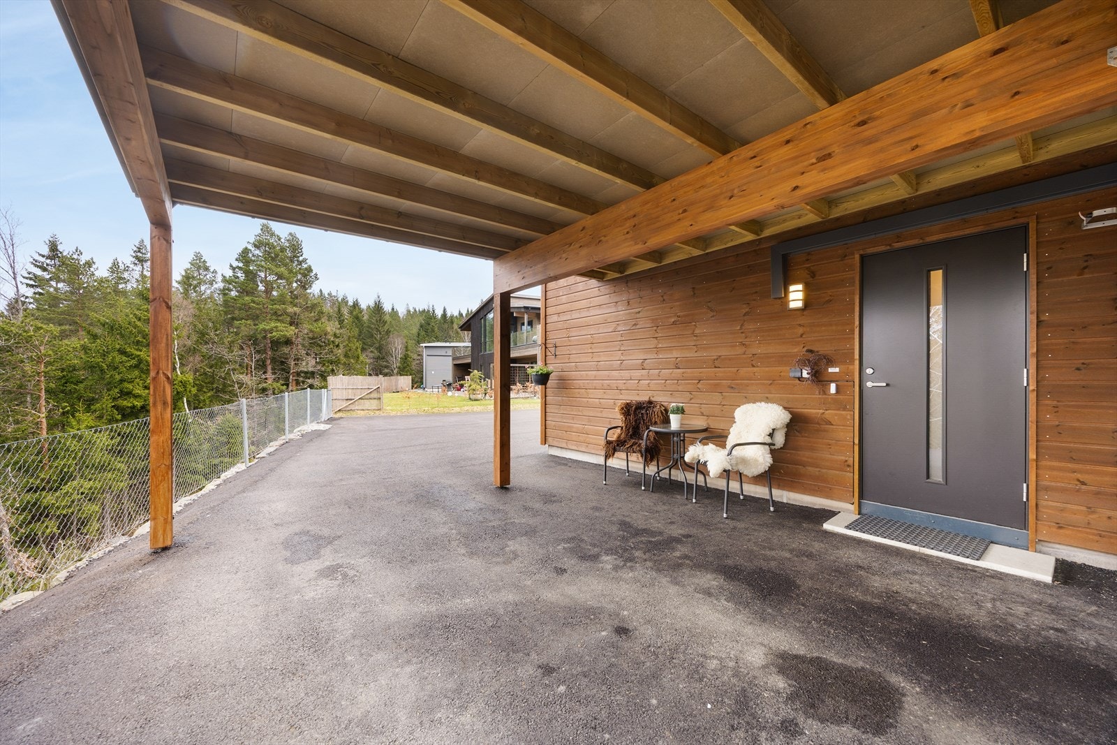 I tilknytning til inngangspartiet har boligen en carport. Her kan man gå tørrskodd fra boligen og inn i bilen. Galleribilde