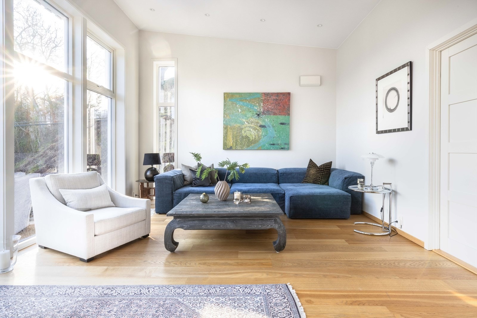 Dobbeltfløyede dører åpner inn til stuen i tilbygget, der rommet løfter seg i høyde og lys. Galleribilde