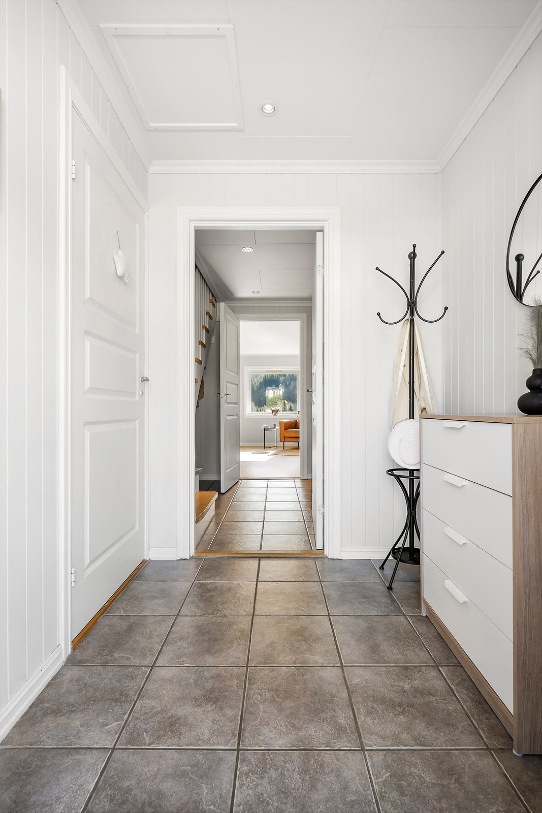 Vindfanget har flislagt golv med varmekabel, som gir ein tørr og varm velkomst. Inngang til badet frå vindfang. Galleribilde