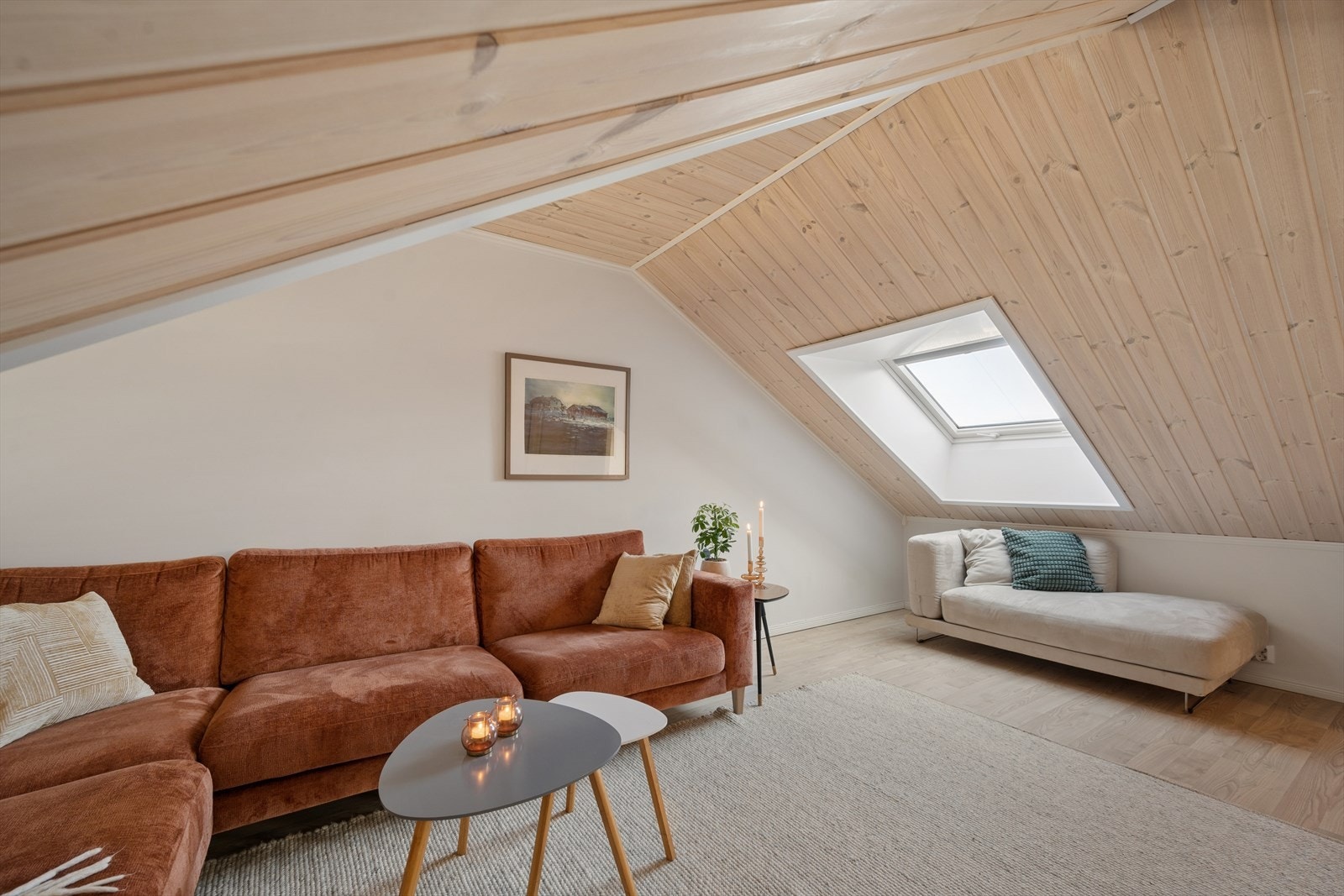 Skråtak med trepanel og to vinduer som slipper inn rikelig med naturlig lys. Galleribilde
