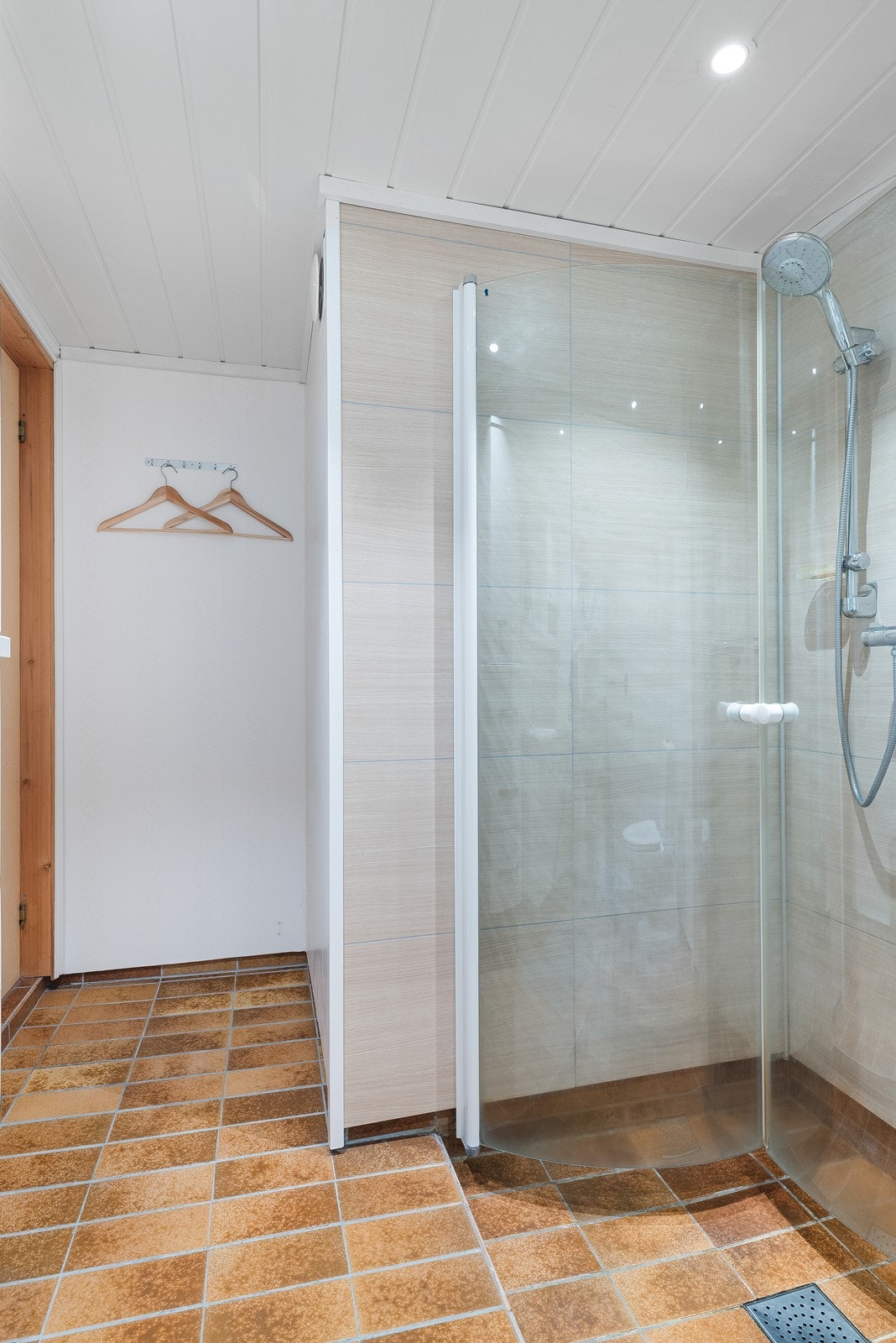 Badet er innredet med wc, dusjløsning med innfellbare glassvegger, og servant med skuffer og skap Galleribilde