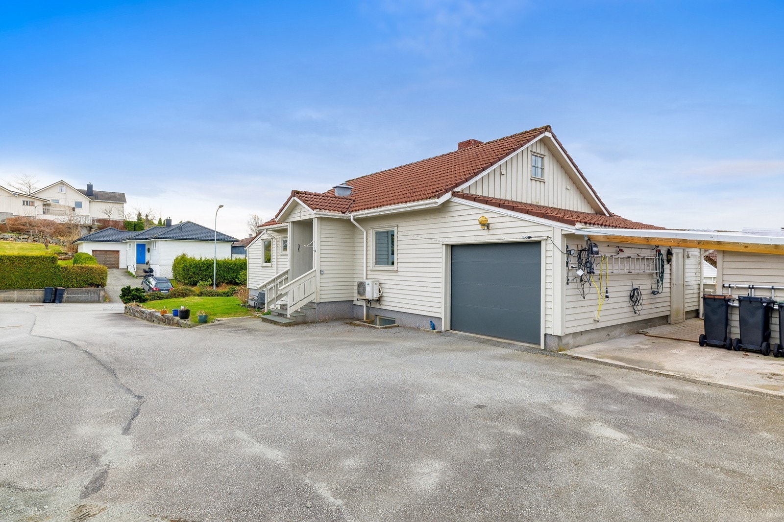 Romslig gårdsrom med god plass til flere biler. Parkering i garasje, carport og biloppstillingsplasser på egen tomt, Galleribilde