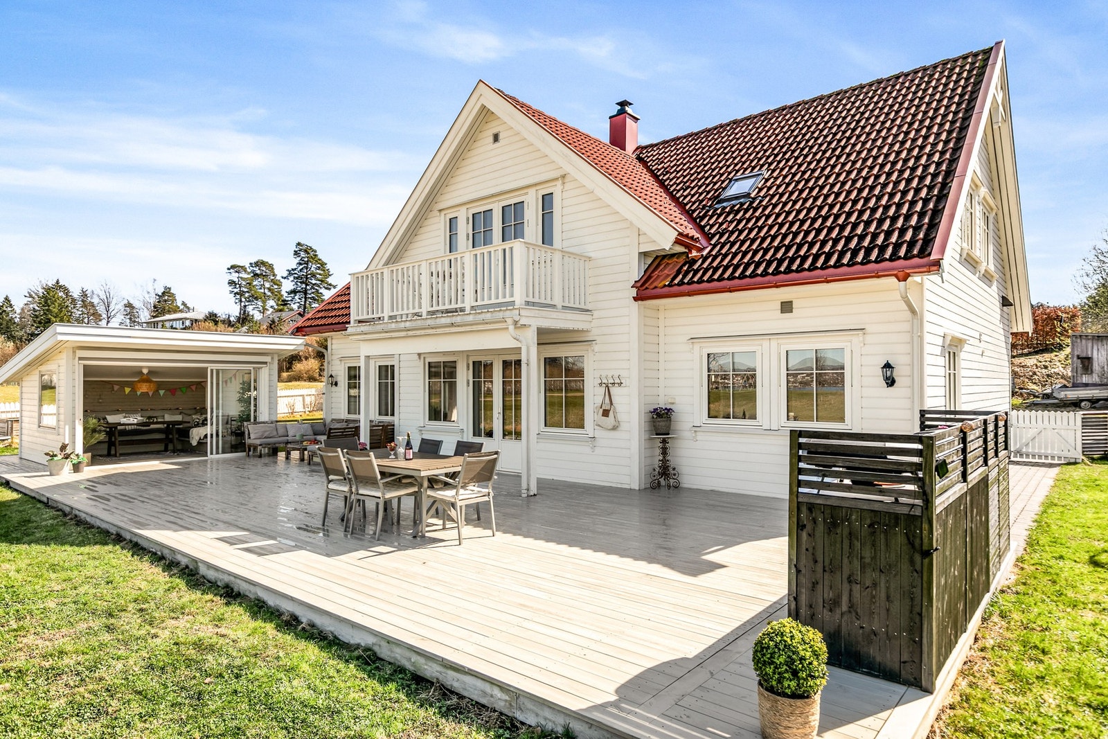 Stor og solrik terrasse med flere soner for både avslapning og sosiale sammenkomster Galleribilde