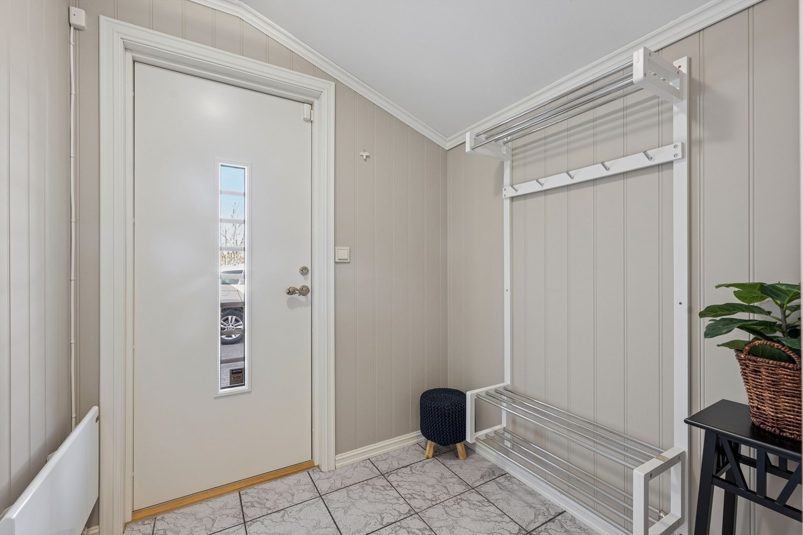 Innvendig ønskes du velkommen til en oppgradert entré med flislagt gulv og malte overflater. Galleribilde