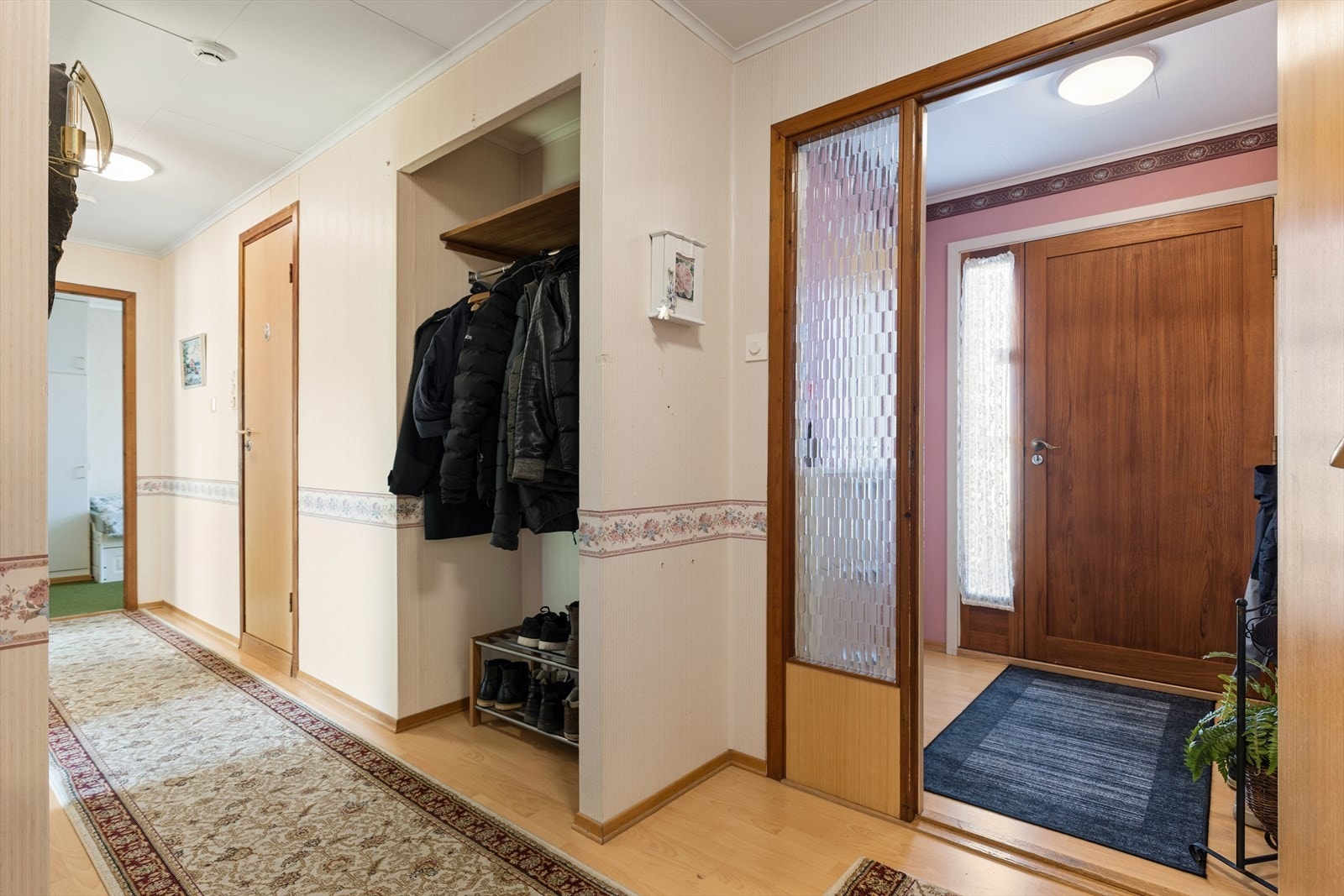 Velkommen inn til en lys og pen entrè med god plass til oppbevaring av yttertøy og sko. Galleribilde