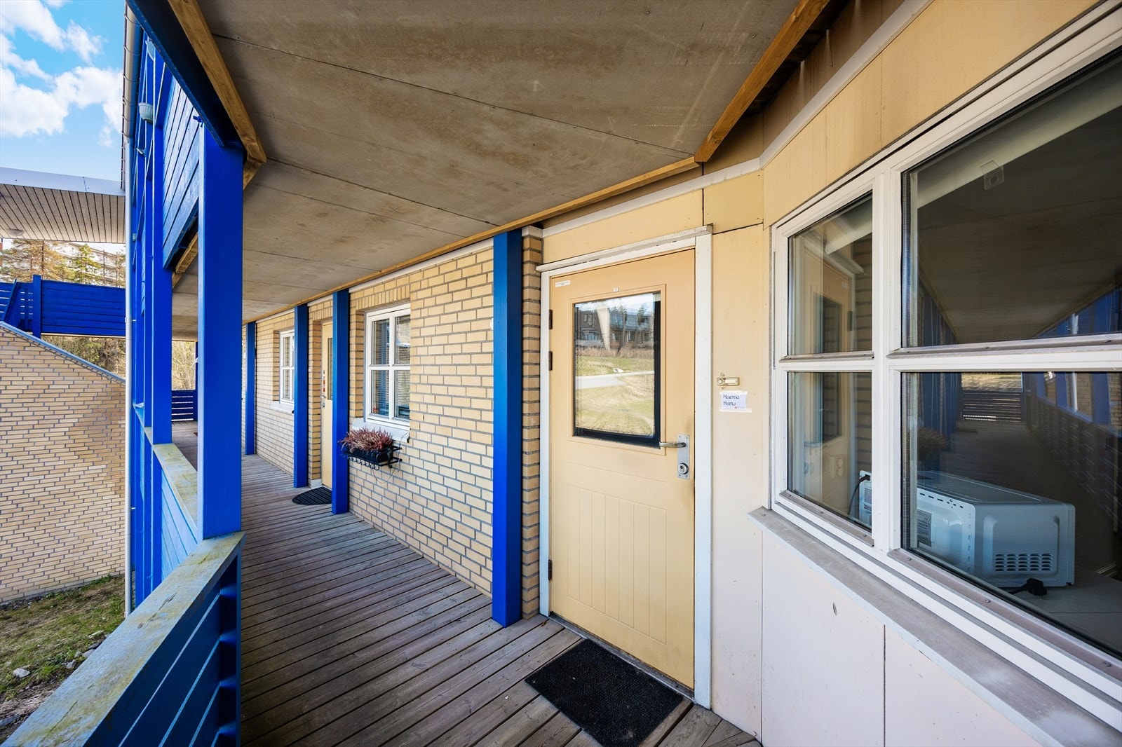 Adkomst til leiligheten via overbygget svalgang. Galleribilde