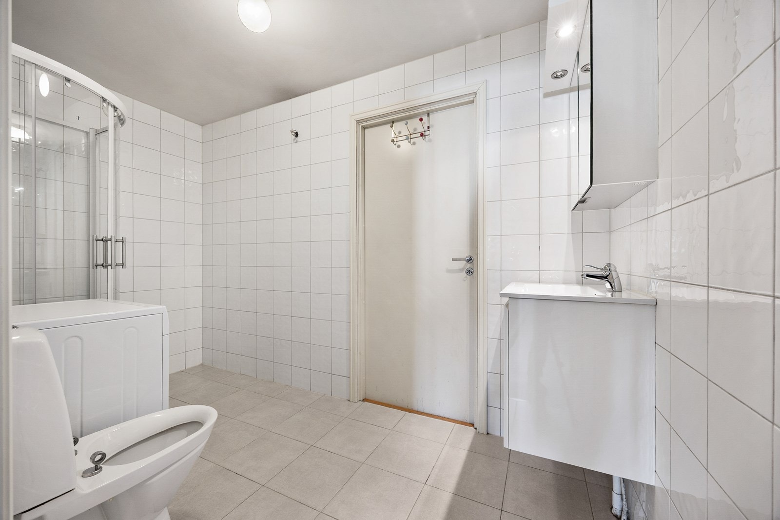 Flislagt bad med varmekabler i gulvet for økt komfort. Rommet er utstyrt med dusjkabinett, toalett og servantseksjon. Galleribilde