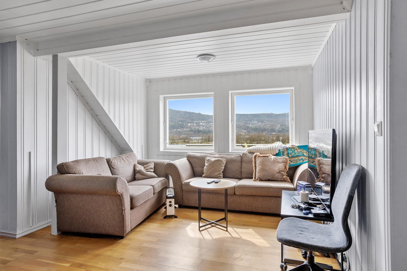 Praktisk loftstue med 3-stavs parkettgulv og panel på vegger og i himling Galleribilde