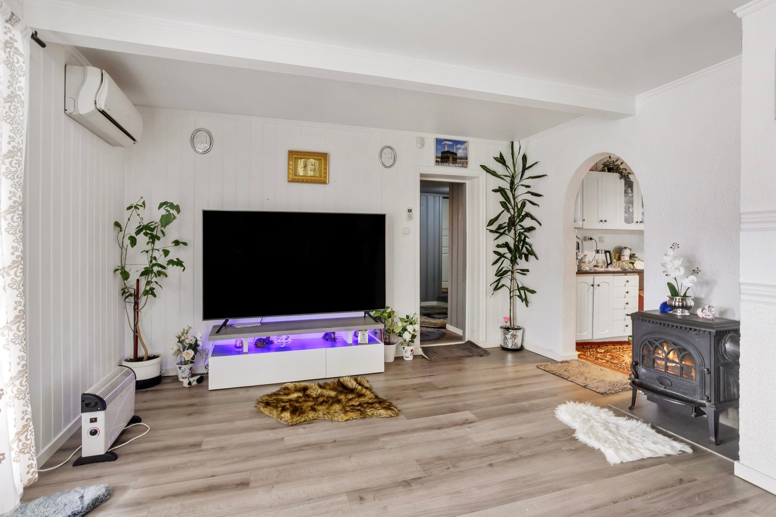 Rommet har plass til sofagruppe og tv-møblement, det er montert både vedovn og varmepumpe Galleribilde