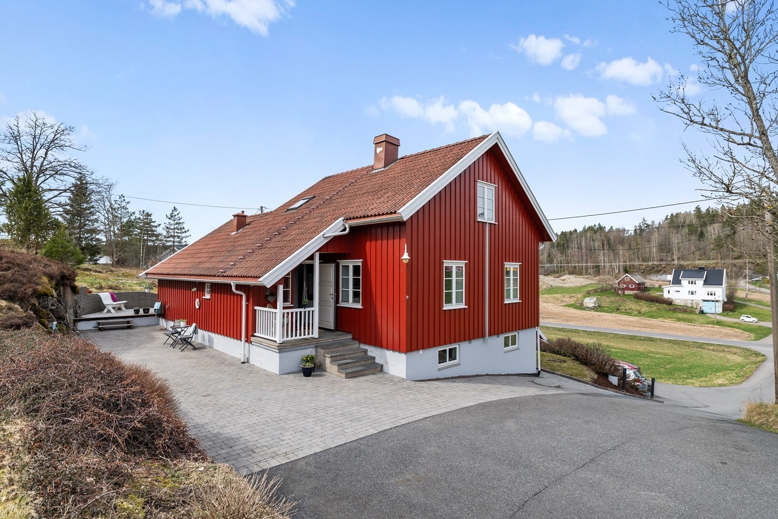 Uteområdet er pent opparbeidet med belegningsstein, asfalt, busker og trær. Det er lagt en stripe med varmekabler i bakken ned. Kablene er lagt på siden mot huset. Galleribilde