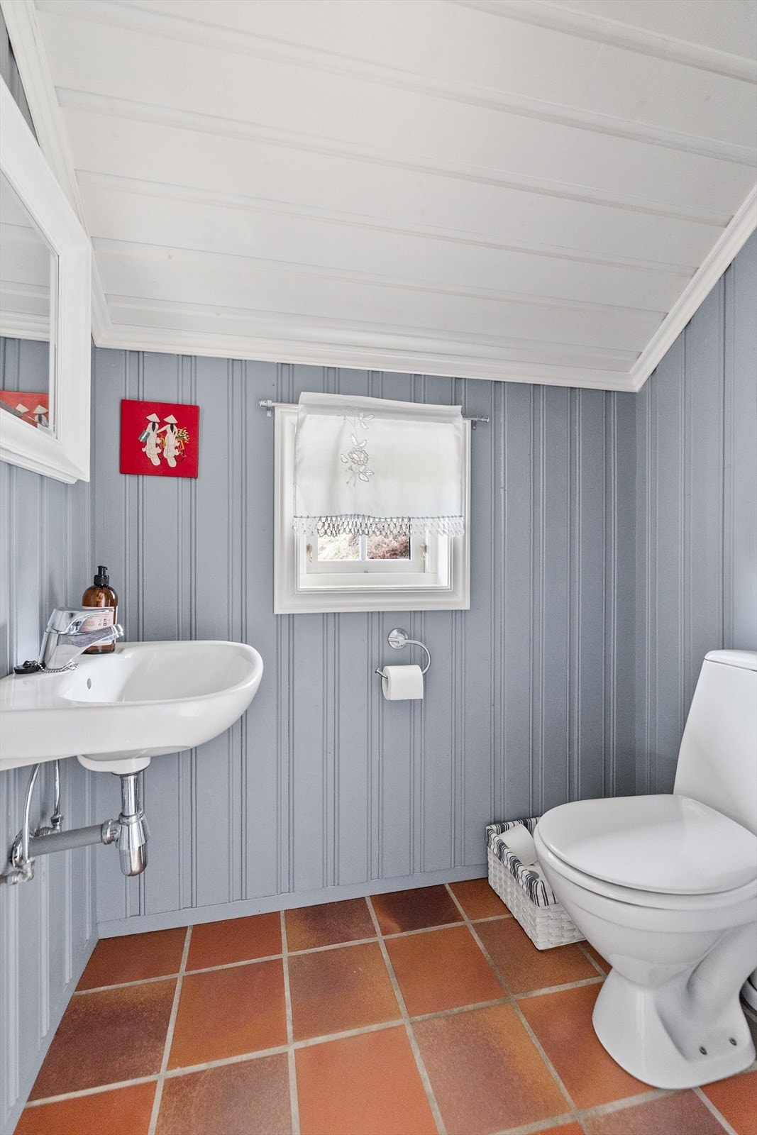 Separat toalettrom i 1. etasje fra 1994 med flislagt gulv og vegger, servant og wc. Galleribilde