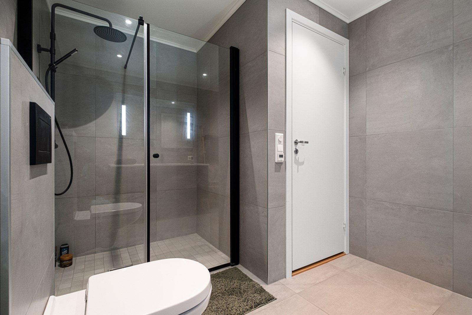 Badet er utstyrt med vegghengt toalett og dusjvegger av glass. Galleribilde
