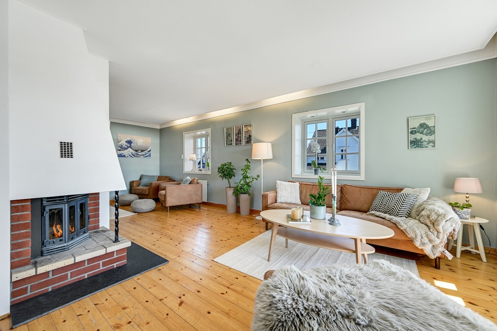 Romslig stue i vinkel med peis. Galleribilde