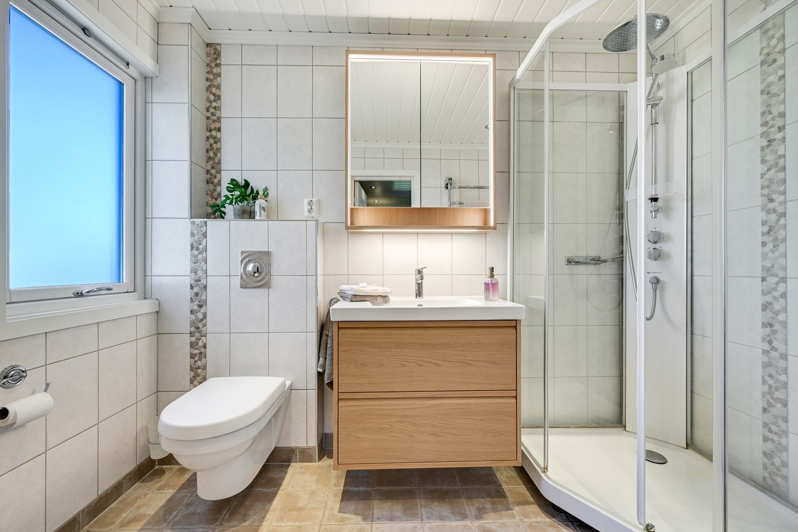 Flott fliselagt bad/wc (2010) med dusjkabinett, vegghengt toalett og ny baderomsinnredning. Galleribilde