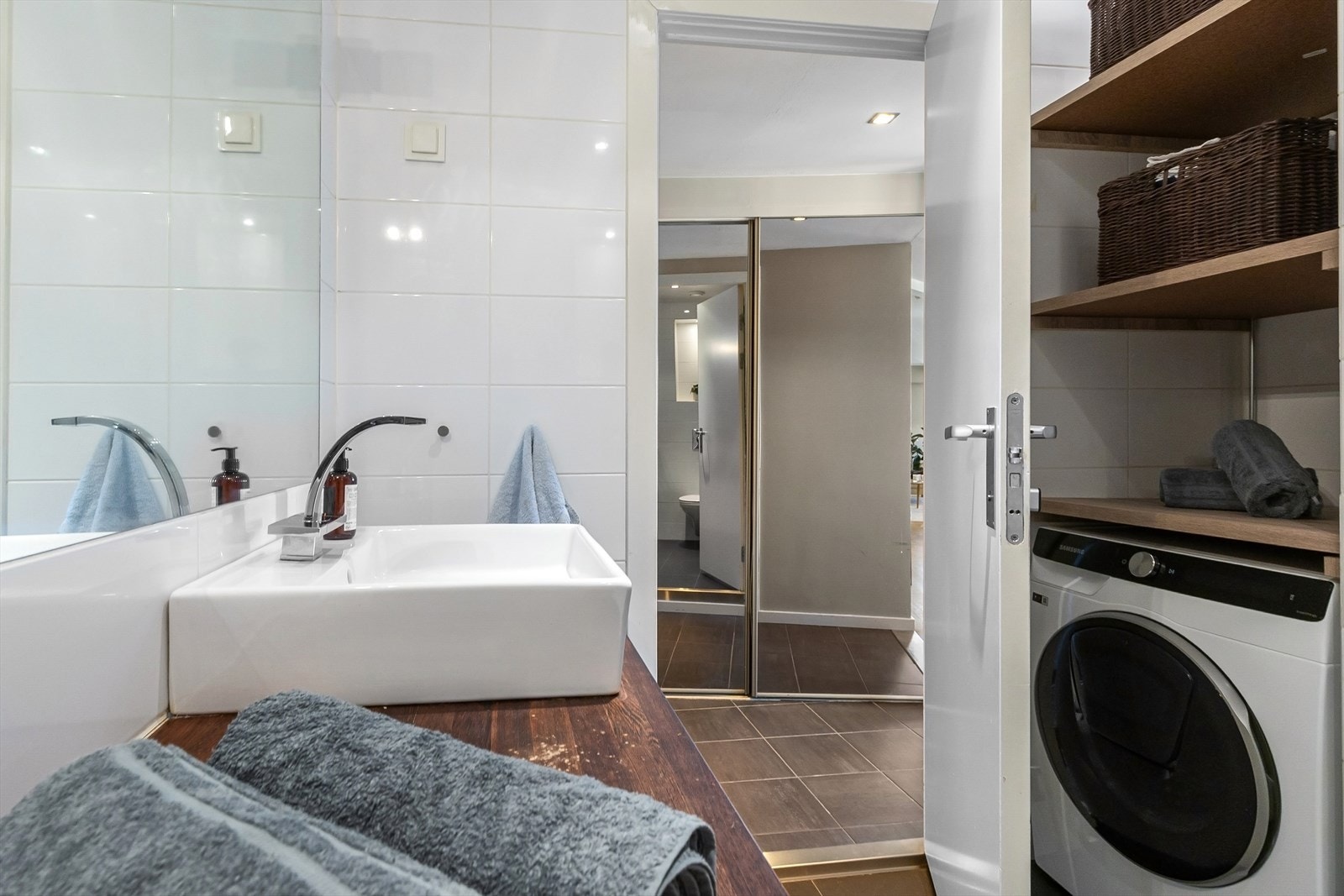 Opplegg for vaskemaskin i en fin og praktisk løsning under innbygde hyller på badet. Galleribilde