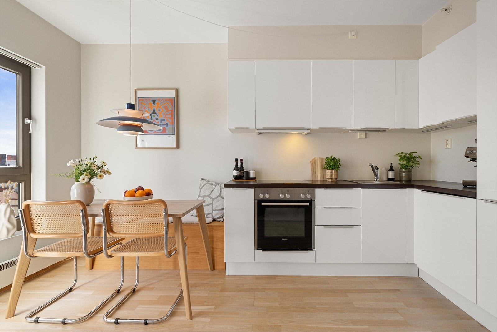 Kjøkkeninnredning fra Gicinque med glatte fronter og laminert benkeplate med nedfelt oppvaskkum i rustfritt stål og svingbart blandebatteri fra Alterna. Galleribilde