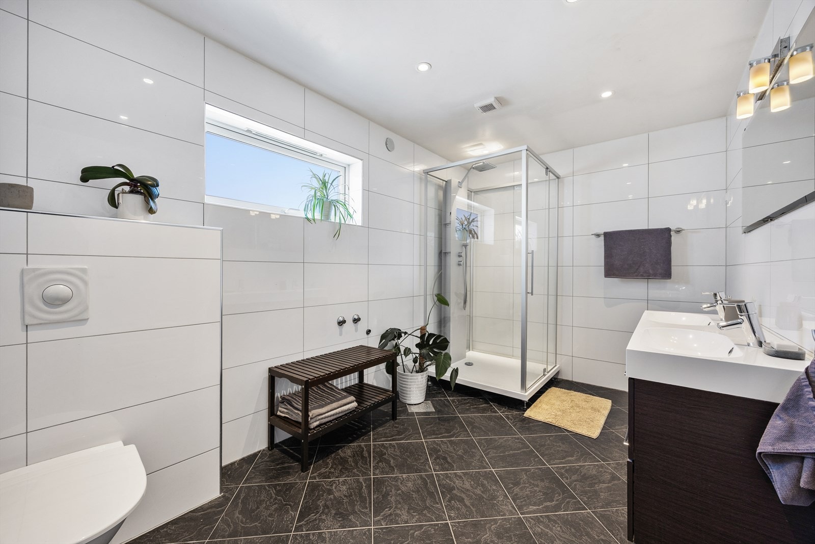 Badet er utstyrt med servant i innredning, vegghengt toalett og opplegg for vaskemaskin. Galleribilde