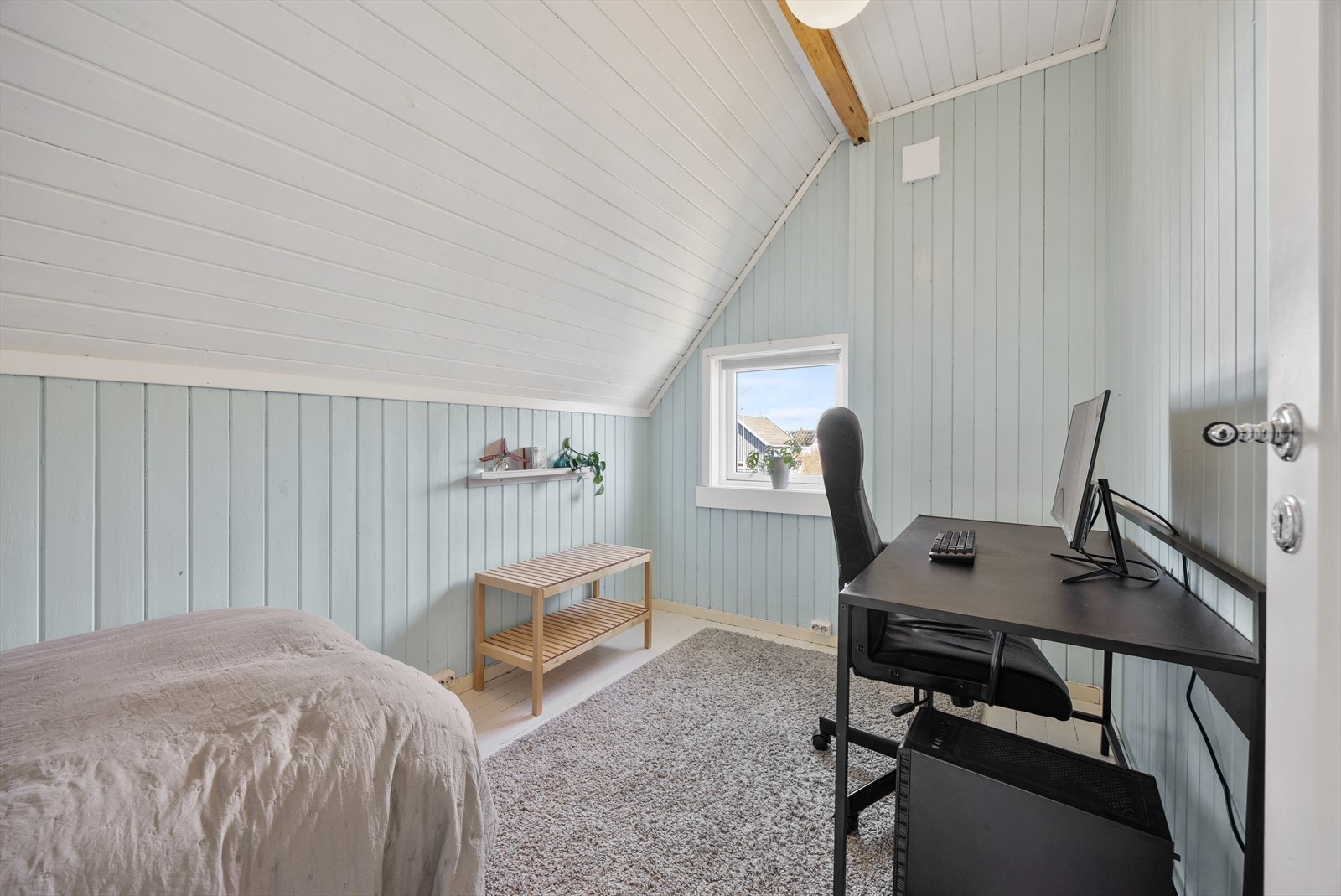 Boden har skråtak og et lite vindu som gir lys i rommet. Galleribilde