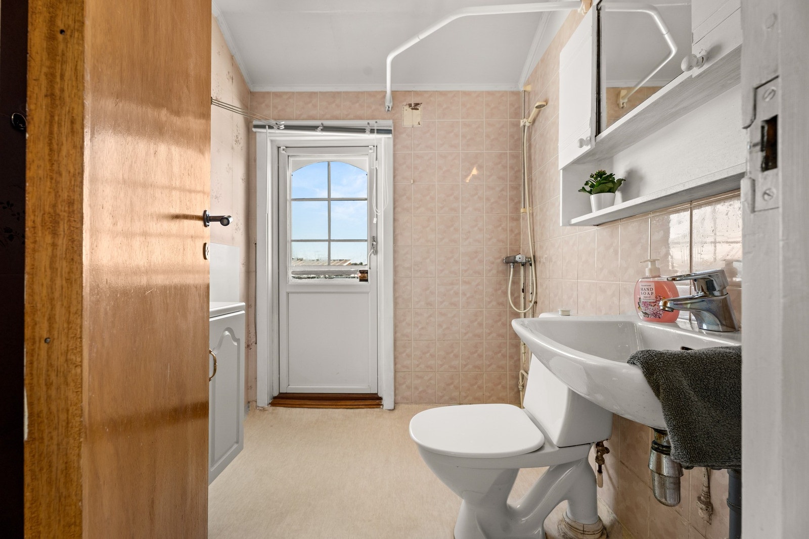 Badet har servantinnredning med skuffer og speilskap, gulvmontert toalett, dusj med forheng. Galleribilde