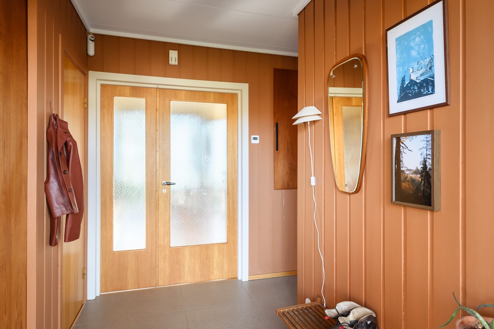 Entréen har flislagt gulv med vannbåren varme. Døren med glassfelt gir et direkte glimt mot biblioteket og hagen. Galleribilde