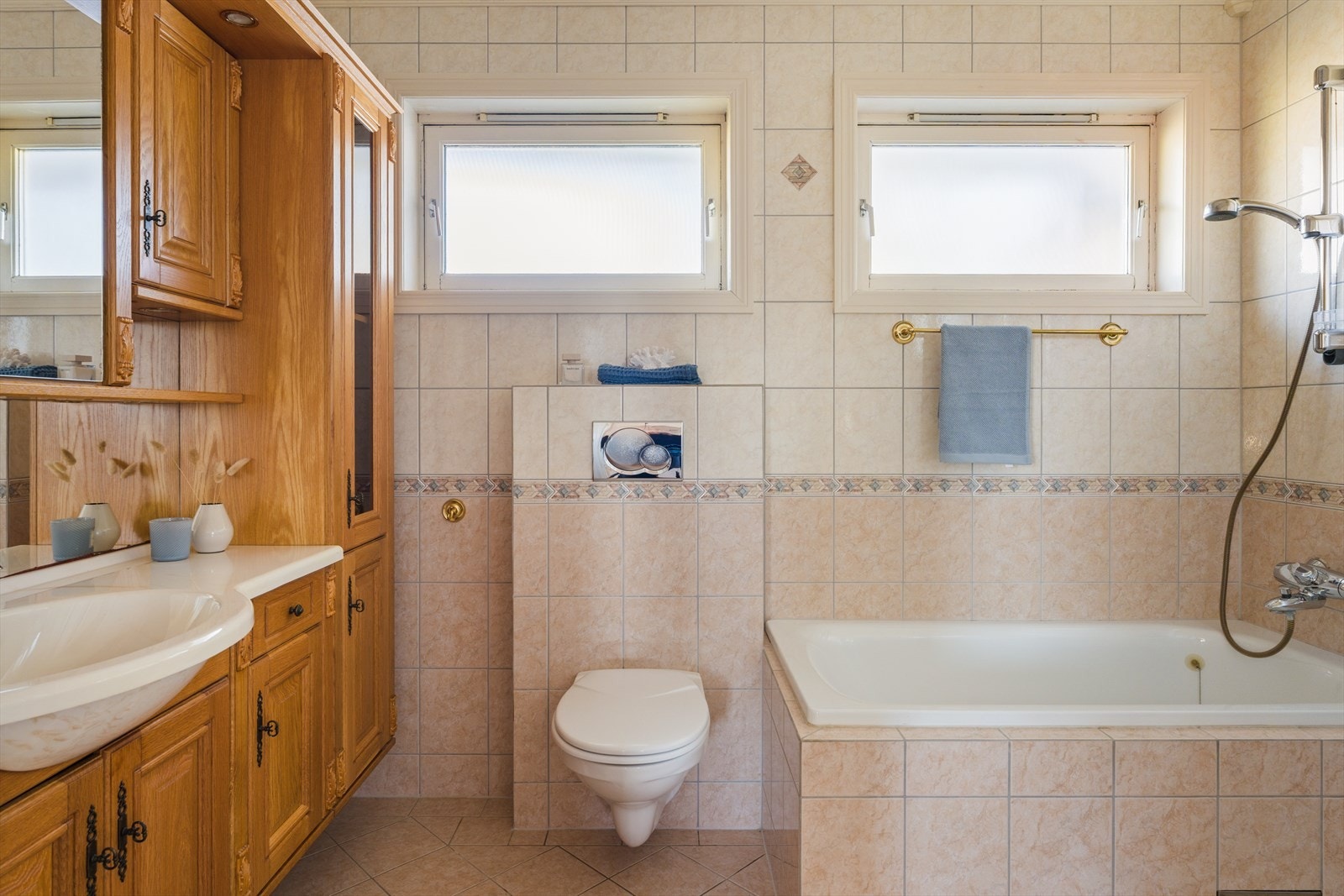 Badet er helfliset med tidløse farger og er utstyrt med nedfelt servant, badekar, toalett og dusjhjørnet. Galleribilde