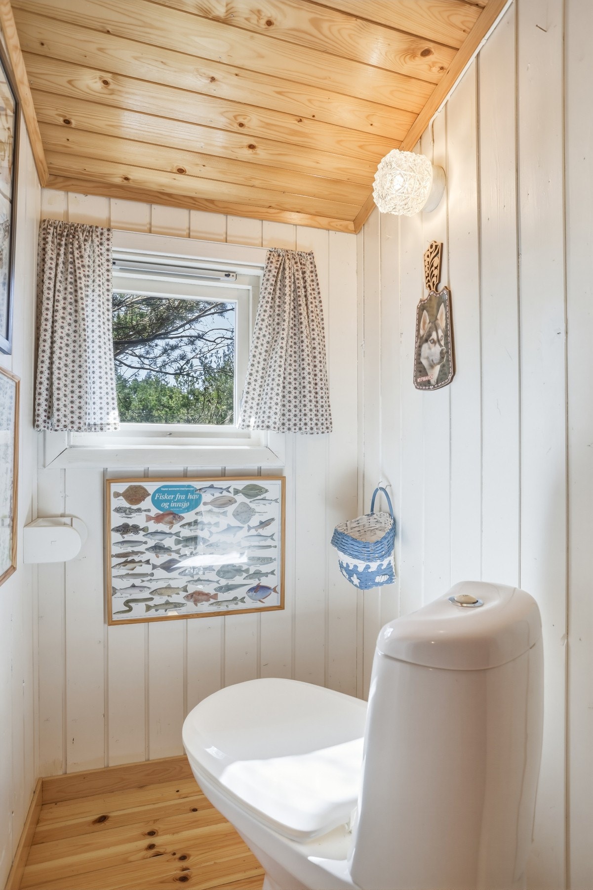 Lyst bad med trepanel på vegger og tak, samt et lite vindu som gir naturlig lysinnslipp. Galleribilde