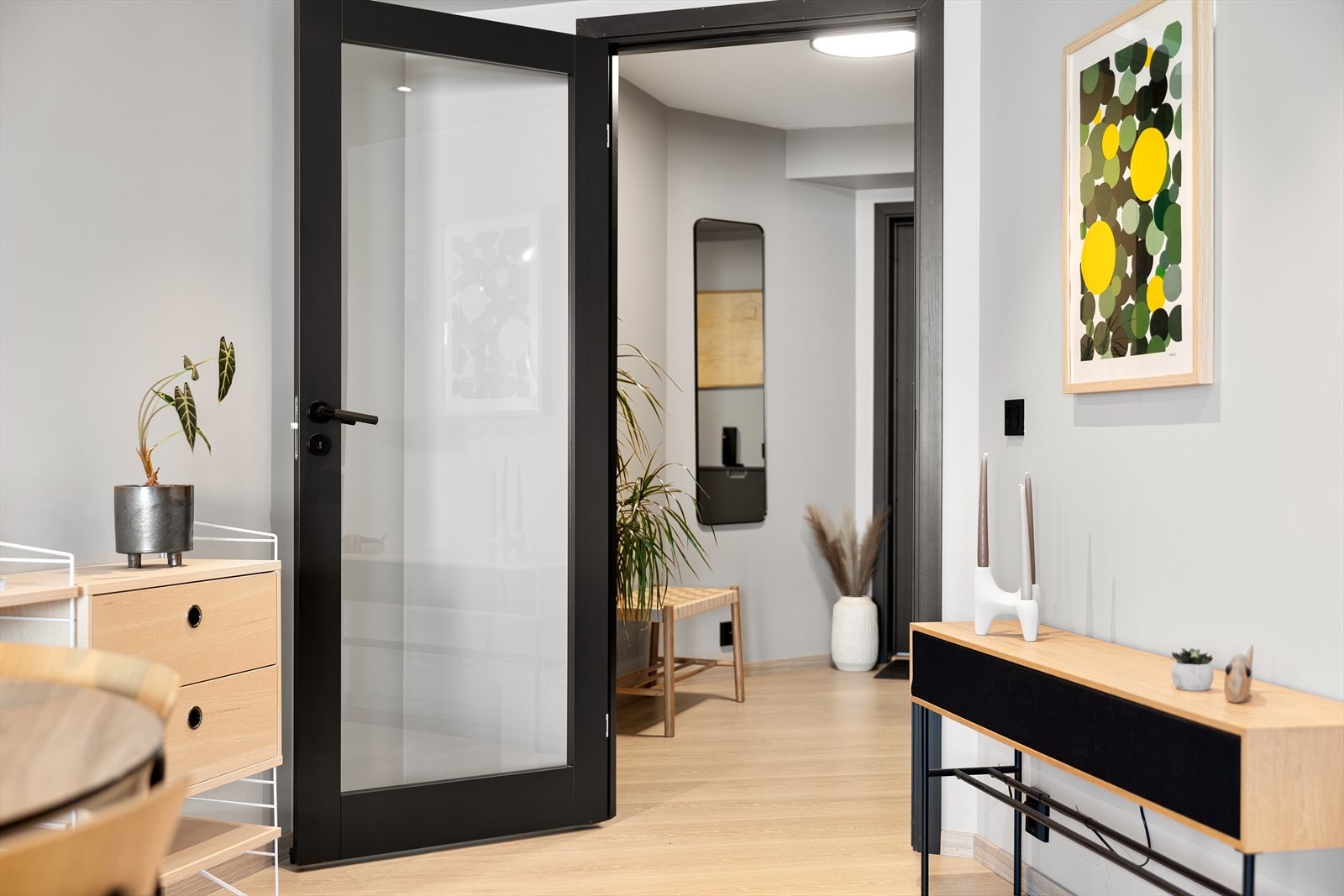 En pen glassdør skiller boligens oppholdsrom fra entréen og badet. Galleribilde