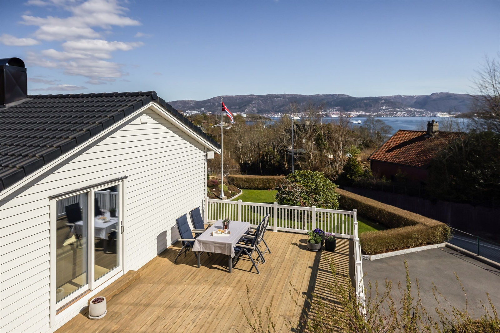 Uteplassen er pent rammet inn med hvitt rekkverk og har direkte tilgang fra stuen. Galleribilde