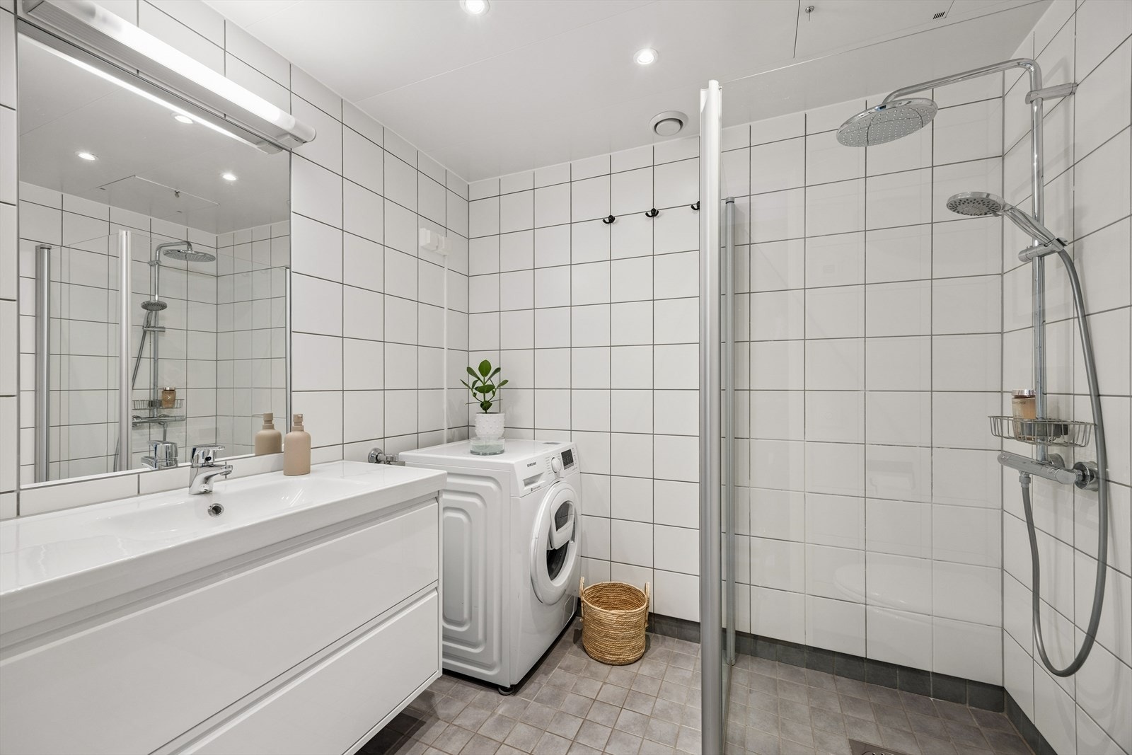 Pent bad med stor dusj og opplegg for vaskemaskin og tørketrommel. Galleribilde
