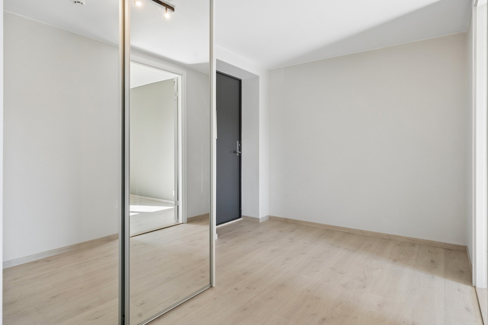Innbydende entré med skyvedørsgarderobe som gir gode oppbevaringsmuligheter og en ryddig første inntrykk av leiligheten. Galleribilde