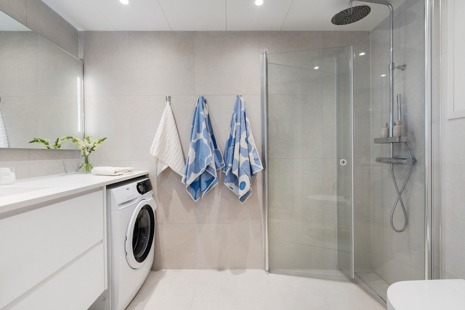 Helfliset baderom med varme i gulv, downlights i himling og opplegg for vaskemaskin Galleribilde